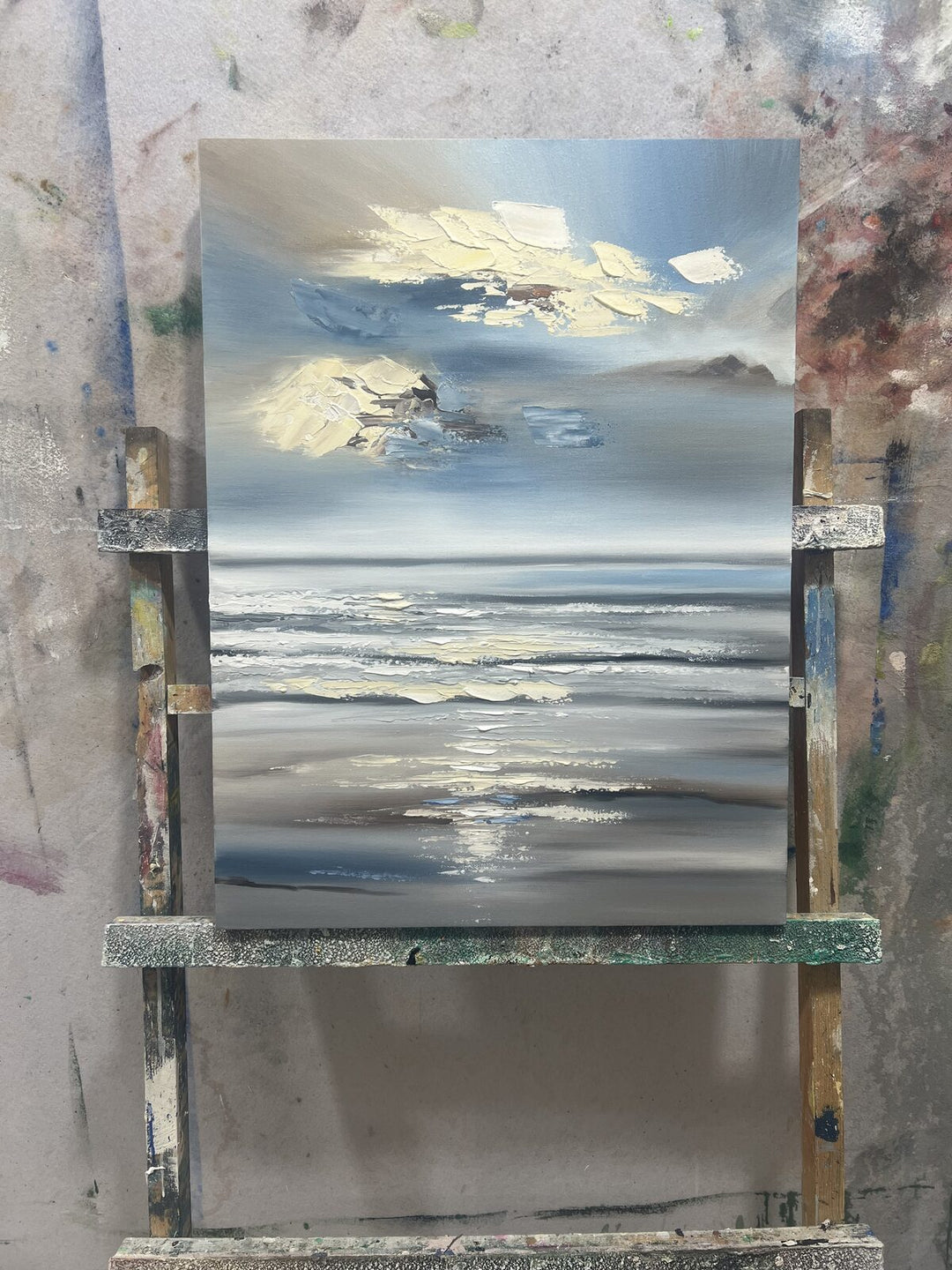 Hand-painted blue and gold textured seascape landscape painting sized as a statement piece above a sofa