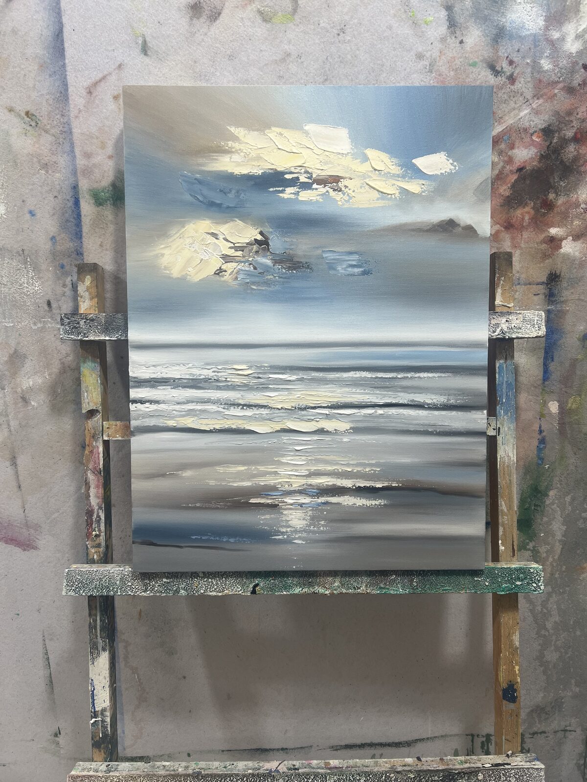 Hand-painted blue and gold textured seascape landscape painting sized as a statement piece above a sofa