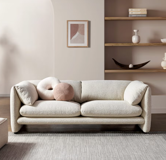 Cream bouclé sofa with large neutral abstract wall art in a modern living room